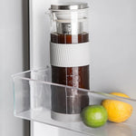 Coffee maker with coffee grounds inside a refrigerator next to fruits