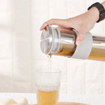 Person pouring tea from a glass teapot into a glass 